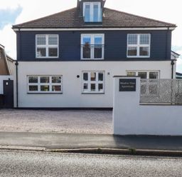 A building with multiple windows and balcony at Meadow View Apartments in Newquay