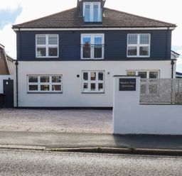 A building with windows and a sign at Meadow View Apartments in Newquay