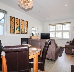 A living room with a dining area and furniture at Apartment 1 in Newquay