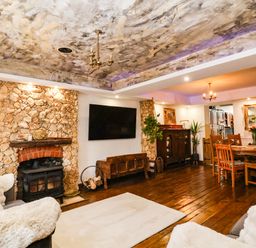 A living room with a fireplace and wooden table at Severnwolf House in Gloucester