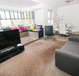 A living room with a television and sofa at 21 Ferrara Square in Swansea