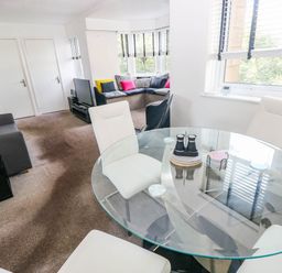 A living room with a dining area and two sofas at 21 Ferrara Square in Swansea