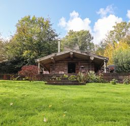 A log cabin with outdoor seating and garden at Thimble Lodge in Gunnislake