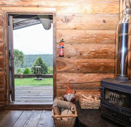 A living room with a door opening to a view at Thimble Lodge in Gunnislake