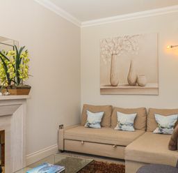 A living room with a sofa, coffee table, and fireplace at 1 Embankment House in Dartmouth
