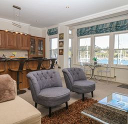 A living room with kitchen area and seating at 1 Embankment House Dartmouth