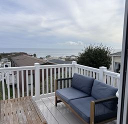 A patio with a sofa and table overlooking the ocean at Club Sahara Sandy Bay, Exmouth