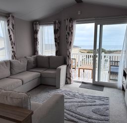 A living room with a sofa and sliding door at Club Sahara Sandy Bay, Exmouth