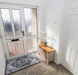 A hallway with a door and a storage bench at 24 Little Castle Grove Hubberston