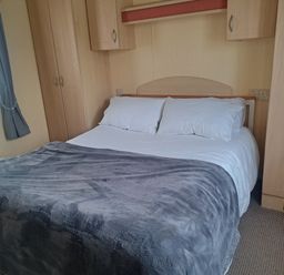 A bedroom with a bed and wardrobe at Chapel Farm Holiday Park No 6 Bunnies View Appleby-in-Westmorland