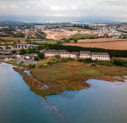An aerial view of buildings next to a body of water at Willow in Kingsteignton