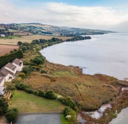 A river with fields and houses along its bank at Moorhen in Kingsteignton