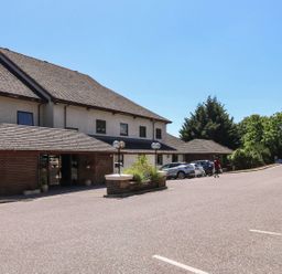 A car park adjacent to a building at Puffin in Kingsteignton