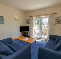 A living room with sofa and television at Egret in Kingsteignton