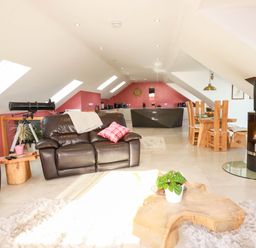 A living room with a telescope and fireplace at Harber Rise in Carlyon Bay