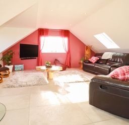A living room with a sofa and TV at Harber Rise in Carlyon Bay