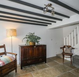 An entryway with a chest of drawers and a chair at Swn y Mor (Wexham), Beaumaris