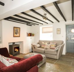 A living room with a sofa and fireplace at Swn y Mor (Wexham) Beaumaris