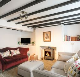 A living room with a sofa, fireplace, and TV at Swn y Mor (Wexham) Beaumaris