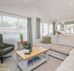 A living room with a sofa, armchair, and coffee table at Thirlmere Scar in Troutbeck Bridge