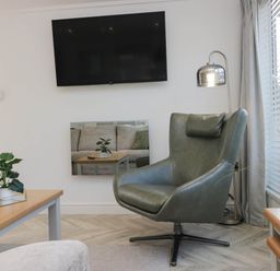 A living room with a chair and a television at Thirlmere Scar in Troutbeck Bridge
