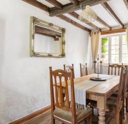 A dining room with a wooden table and chairs at the property 
