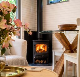 A living room with a wood stove and dining table at the property in location