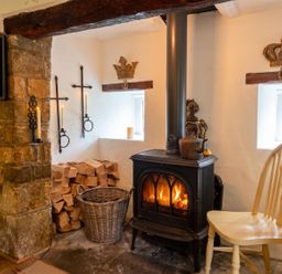 A living room with a fireplace and wood storage at The Old Barn in Manchester