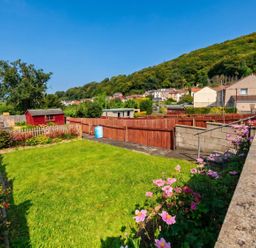 A garden with a lawn, flower bed, and shed at the property