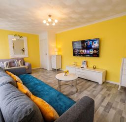A living room with a TV and sofa at The Old Barn in Manchester