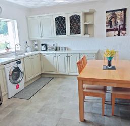 A kitchen with a table and chairs at the property in location