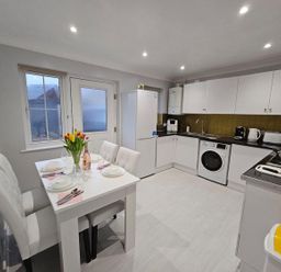 A kitchen with a dining table and appliances at The Old Barn in Manchester
