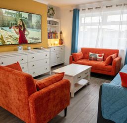 A living room with orange sofas and a television at the property