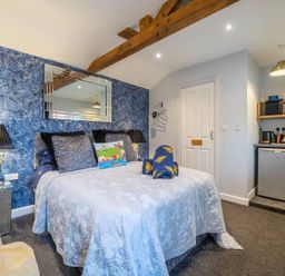 A bedroom with a bed and kitchenette at The Old Barn in Manchester