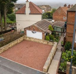 An outdoor view of a house and garage with a garden area at a residential property