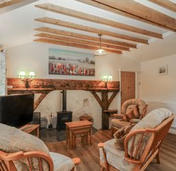 A living room with a sofa and a television at Bryn Eithin in Penygroes