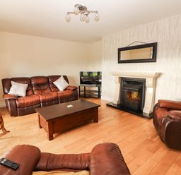 A living room with a fireplace and television at Wild Atlantic Ferry View in Kilrush, County Clare
