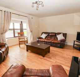 A living room with a sofa and coffee table at Wild Atlantic Ferry View in Kilrush, County Clare