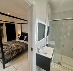 A bedroom with a bed and a bathroom with a sink and shower at Jeannies retreat at little lake fb