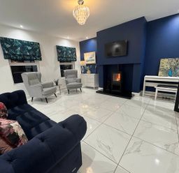 A living room with a sofa, two armchairs, and a fireplace at Jeannies retreat at little lake fb