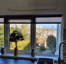 A kitchen with a window view and flowers in a vase at 1 Bedroom Apartment with Sea View, Mevagissey