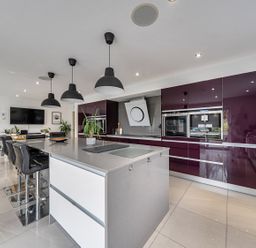 A kitchen with bar stools and a kitchen island at 5 Bed House, Sleeps 14 with Hot Tub and Bar Tavistock