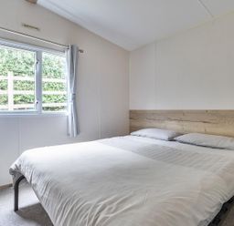 A bedroom with a bed and window at Ty dee seaview escapes in Looe
