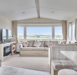 A living room with a sofa and television at Ty dee seaview escapes in Looe