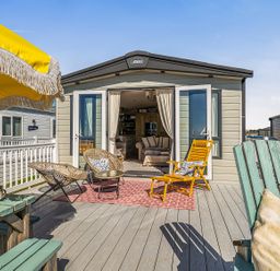 An outdoor area with chairs and an umbrella at 2 Bed Caravan, Sleeps 4 with Sea Views, West Lulworth