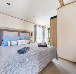 A bedroom with a bed and dresser at 2 Bed Caravan, Sleeps 4 with Sea Views, West Lulworth