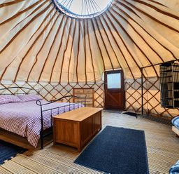 A bedroom with a bed and dresser at Yurt, Sleeps 2 with BBQ and Fire Pit, Tregooden Farm near St Tudy