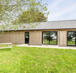 A building with large windows and a table in an outdoor area at Yurt, Sleeps 5 and Dogs Welcome