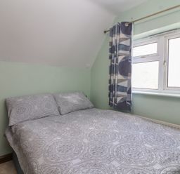 A bedroom with a bed and window at 19 Hailey Road