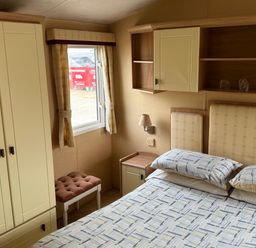 A bedroom with a bed and storage furniture at Haven Perransands, Perranporth
